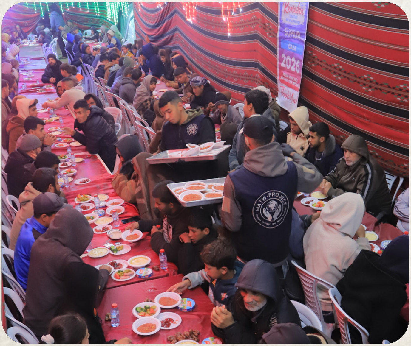 Hundreds of families seated at long communal tables in Gaza, sharing a hot meal together at a Najam-funded distribution in Gaza