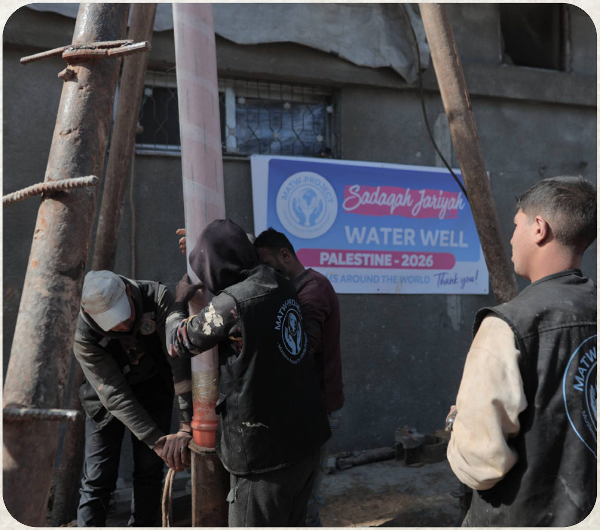 Workers completing a groundwater well in Palestine beneath a Najam Water Well banner